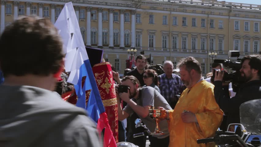 SAINT-PETERSBURG, RUSSIA - MAY 7, 2016. Bikers parade and show. Orthodox priest sprinkles holy water to people