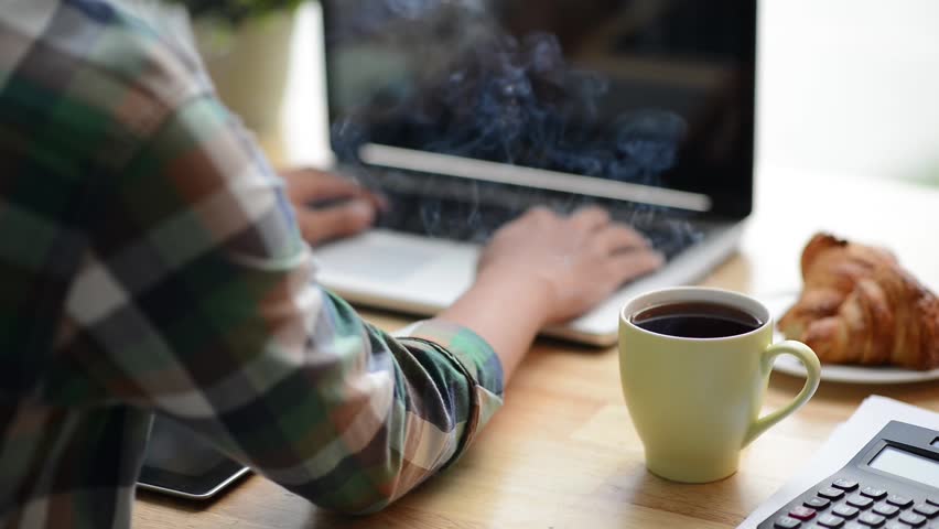 Cinemagraph of steaming coffee on desk of young programmer  | Shutterstock HD Video #17121097