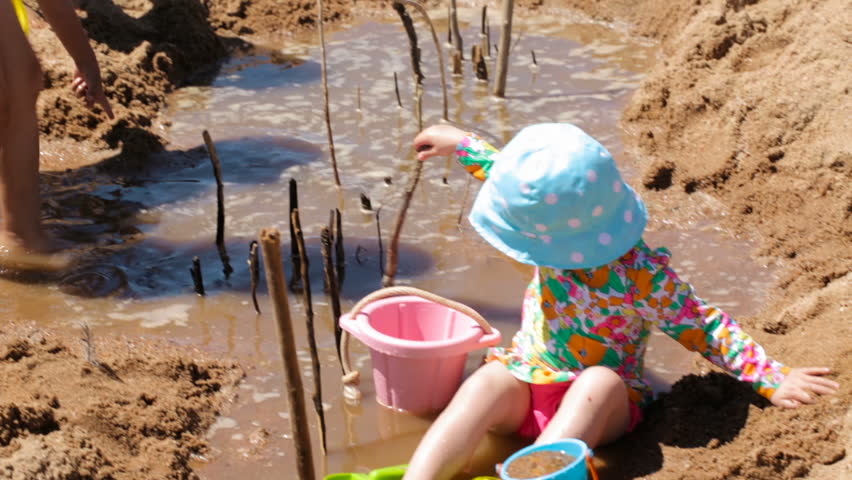 Toddler playing with sand toys on the beach.