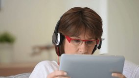 Senior woman listening to music on tablet