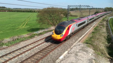Northamptonshire, UK - May 06, 2016: A Virgin Trains Pendolino tilting electric express passenger train traveling north at speed on the West Coast mainline railway in England.