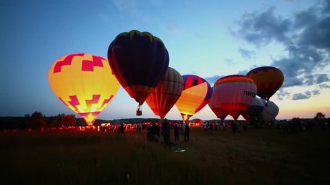PERESLAVL ZALESSKY - JUL 18, 2015: Grass field with crowd of people which stand near air balloons prepared for flight during holiday