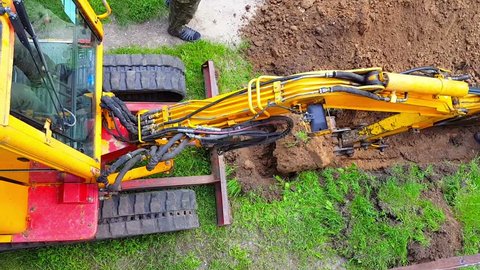 Top view of excavator digging a trench for laying cables