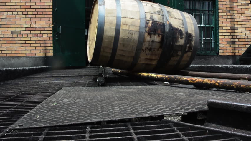 Bourbon Barrel Rolling on Track outside of brick distillery building
