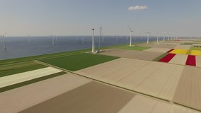 Aerial video footage of a wind park in a typical landscape with the north sea and wind engines in the netherlands near Amsterdam