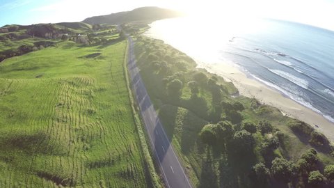 Aerial view of scenic coastal highway at sunrise at Pouawa Beach, New Zealand