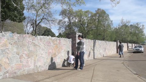 MEMPHIS, TENNESSEE - APRIL 09, 2016: Elvis Presley Mansion Wall in Graceland, Memphis. Family and childrens are looking into the wall