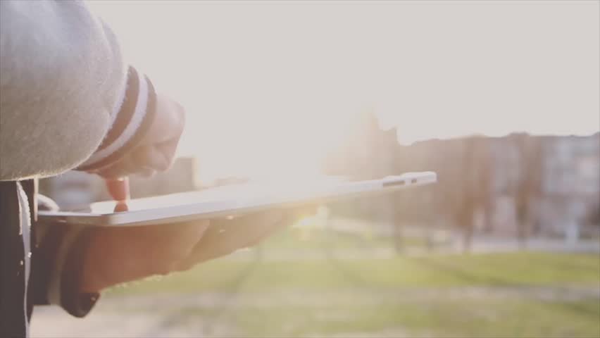 Man Working on a Tablet on The Sunset Background
