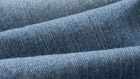 Blue denim gathers and details of texture close-up  tilting 4K 2160p 30fps UltraHD video - Dugaree blue jeans high quality cloth gathers close-up slow tilt 4K 3840X2160 UHD footage