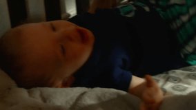Video of Caucasian Baby Boy being lifted and kissed in his crib by his mom