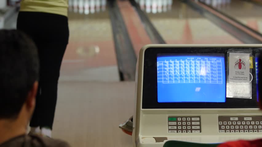 A family plays a game of bowling in a small town bowling alley
