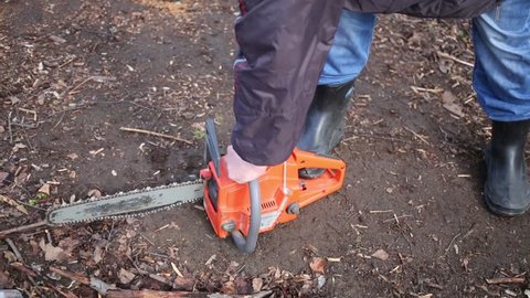 MOSCOW, RUSSIA - MAY 1, 2015: Man unsuccessfully trying to start chainsaw in a grove