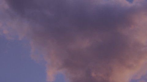 Chimney at industrial plant - slow motion smoke being expelled at sunset