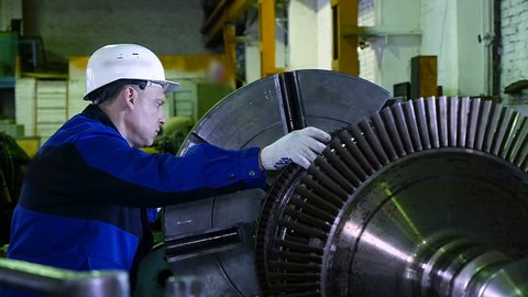 lathe operator in a factory for the production repair rotor for compressor turbine