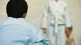 Martial arts instructor training children in gym