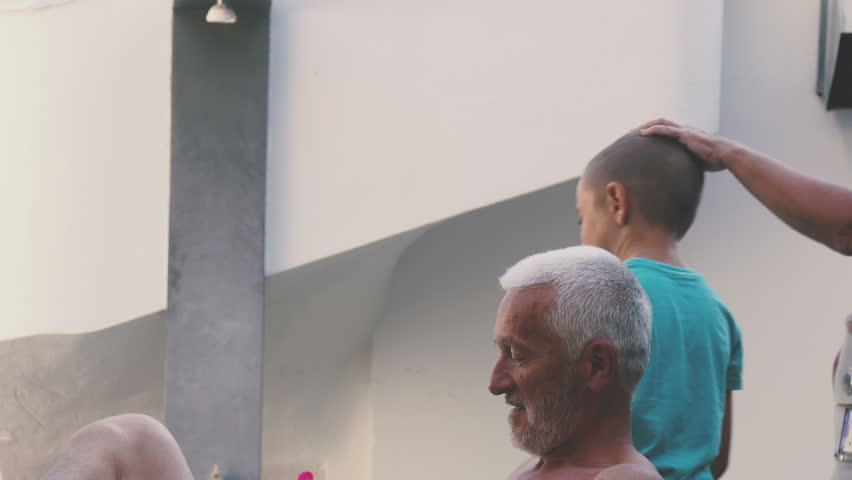Grandfather shooting a plastic gun with his grandson while grandmother is pas
