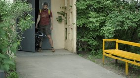 Man with beard folding bicycle near home
