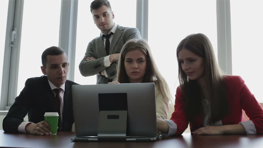 Office and teamwork concept - group of business people having a meeting. People are smiling and laughing looking ta the screen of the laptop.  | Shutterstock HD Video #17188141