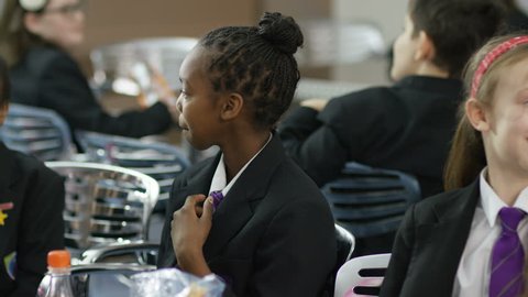 4K Portrait of young girl talking to friends in school cafeteria. Shot on RED Epic. UK - April, 2016
