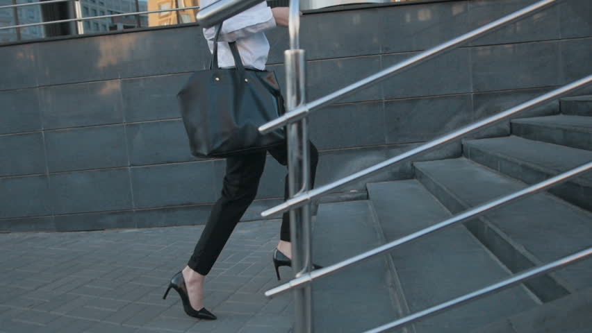 Businesswoman Legs In High-Heeled Shoes Walking Up Stairs On Stairway. Sexy Woman near Office after Work. Student girl go to lessons.