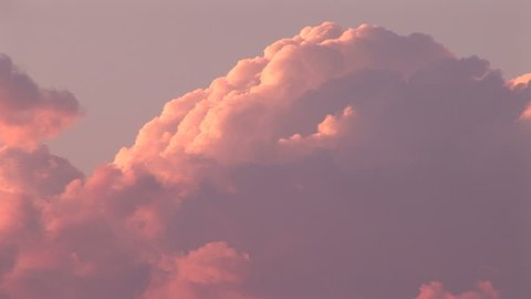 Cumulus clouds tinted pink and purple from sunset