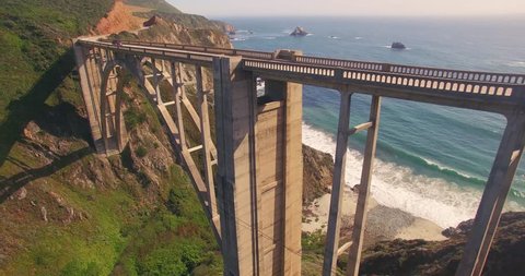 Camera ascending over Bixby Creek Bridge on PCH Highway 1 with Pacific Ocean in background. Monterey, Big Sur, California. 4K UHD aerial view.