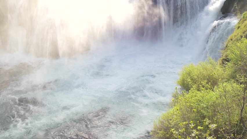 falling waterfall at river sun rays