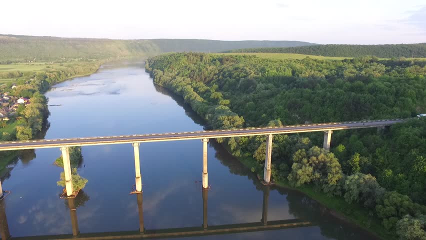 Aerial view. Flight over the river and bridge. Suny day. Amazing view green tree.