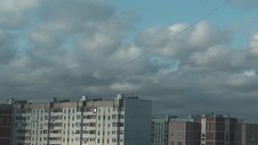 Time lapse clip of clouds over town houses.
