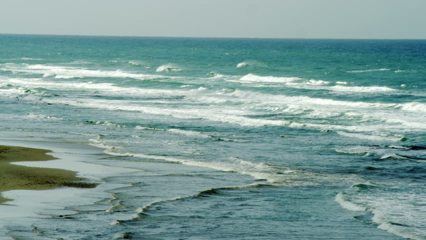 White caped waves lapping on the Israeli blue watered Mediterranean shore. 