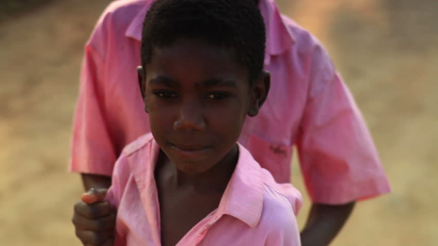KENYA, AFRICA - CIRCA 2011: A little girl who looks very sad, little boy comes