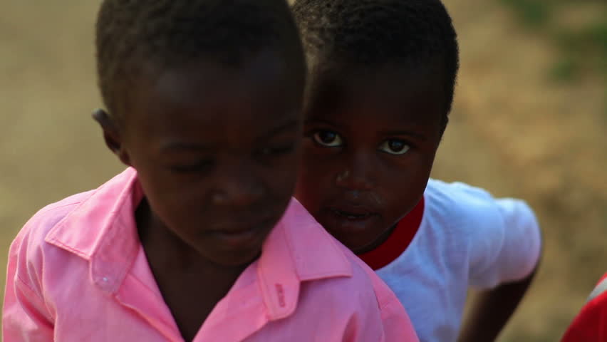 KENYA, AFRICA - CIRCA 2011: A boy hiding behind another boy.