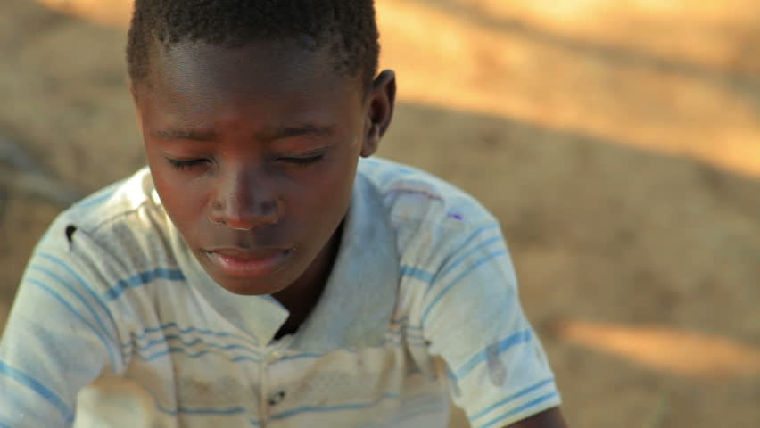 KENYA, AFRICA - CIRCA 2011: A boy in a striped shirt looking at the camera.