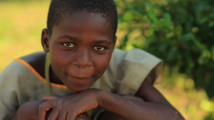KENYA, AFRICA - CIRCA 2011: A girl with hands on her knees looking at the