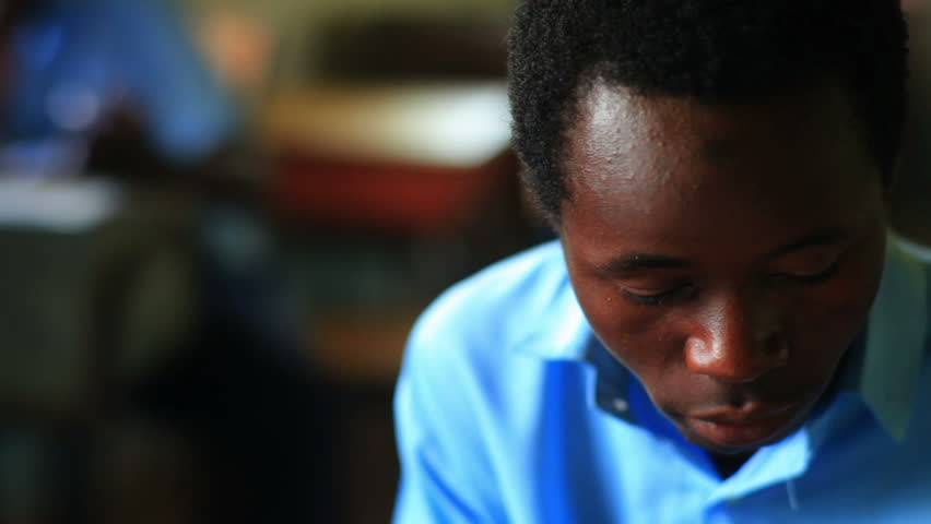 KENYA, AFRICA - CIRCA 2011:  A teen boy in a blue shirt looks at the camera.