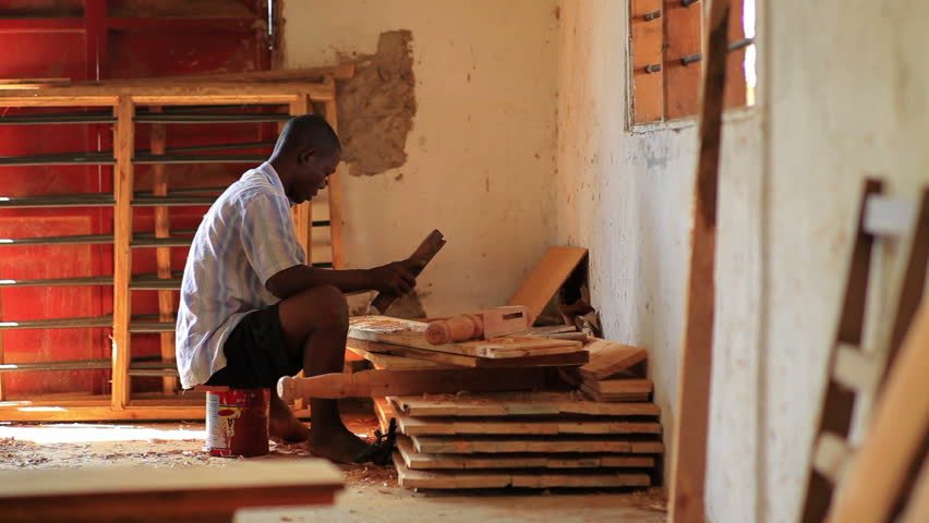KENYA, AFRICA - CIRCA 2011: Man chiseling wood.