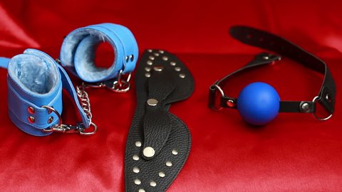 Leather accessories sex. female hand takes sex toy. mask, handcuffs and a gag