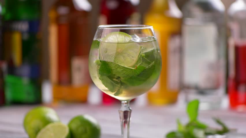Tongs put lime into beverage. Drink with mint and lime. Hugo cocktail served at pub. Champagne and sweet syrup. Royalty-Free Stock Footage #17245738