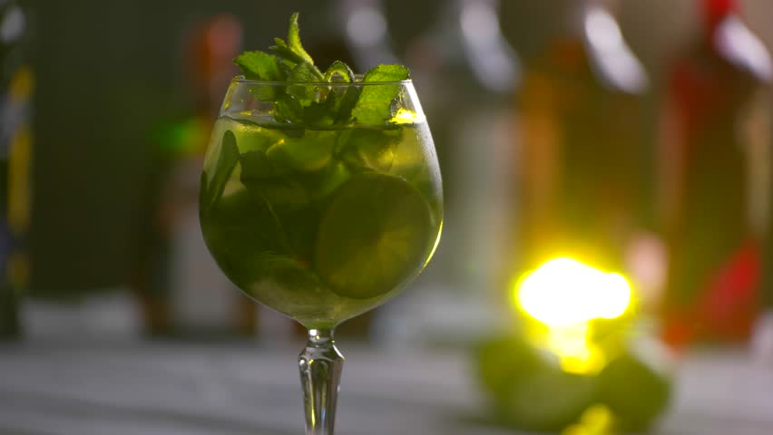 Glass of cocktail is rotating. Drink with ice and mint. Refreshing taste of hugo cocktail. Fresh beverage in local club. Royalty-Free Stock Footage #17245921