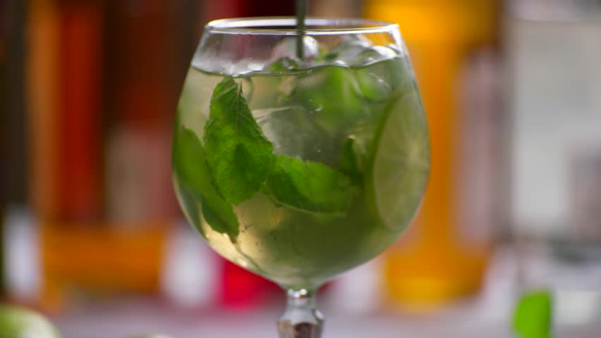 Green drink in a glass. Spoon rapidly mixing beverage. Juicy lime and fragrant mint. Chilled hugo cocktail. Royalty-Free Stock Footage #17245972