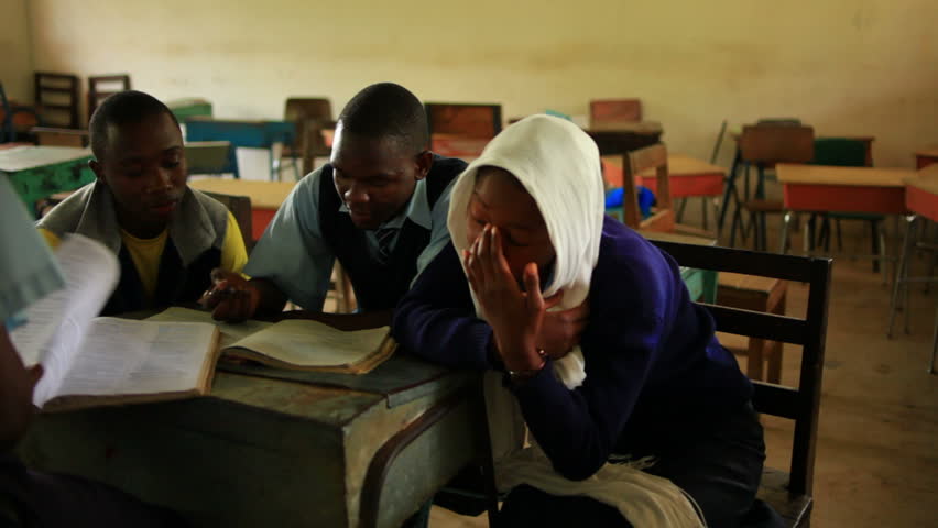 KENYA, AFRICA - CIRCA 2011: Shot of 2 school boys and 1 girl getting something