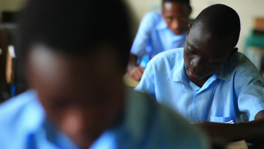 KENYA, AFRICA - CIRCA 2011: Shot of a school boy reading his book in class, then