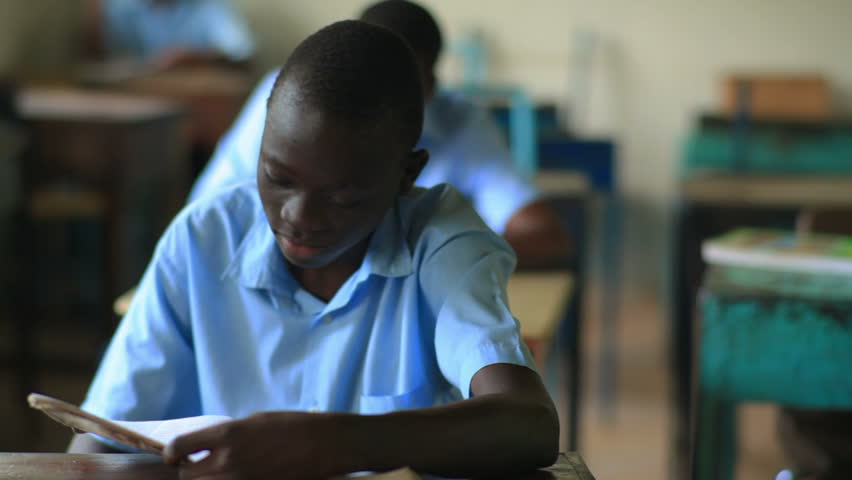 KENYA, AFRICA - CIRCA 2011: Shot of a school boy reading his book in class in