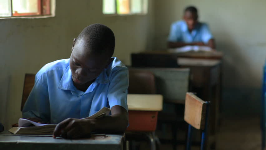 KENYA, AFRICA - CIRCA 2011: Shot of a school boy reading his book in class in