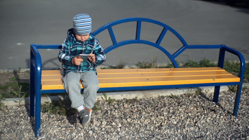 Child playing with smart phone outdoor