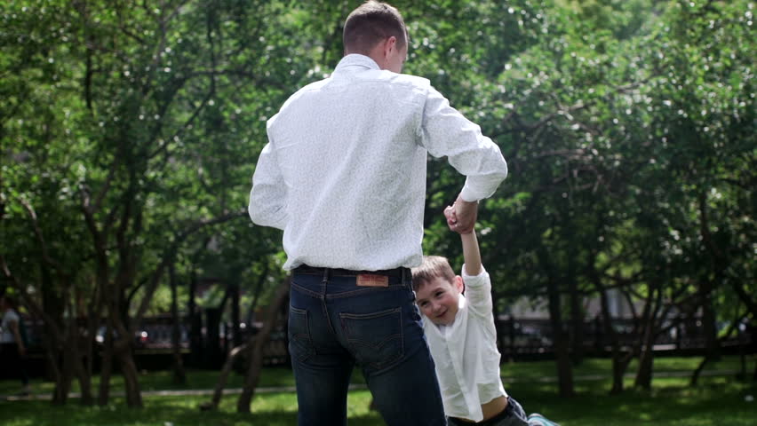 Young father having fun with her son in beautiful summer park, slow motion