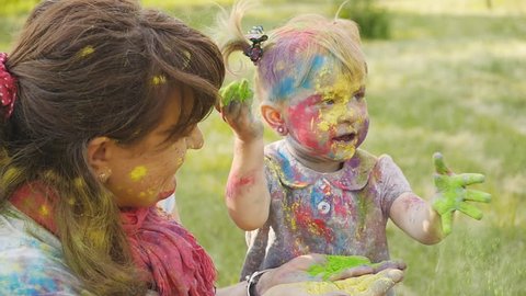 Family playing in the park. Family painted in the colors of Holi Festival Video Stok