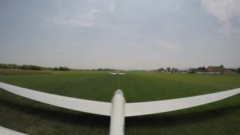 Glider (sailplane) take off from a small grass airfield. Gliders take off by aerial towing made by a motor aircraft.  4K Ultra HD action video captured with GoPro on the glider tail.
