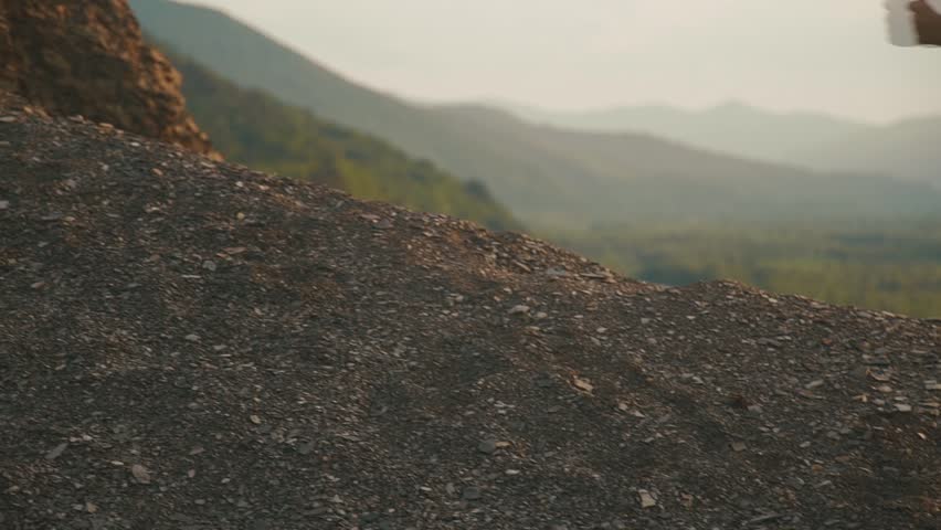 Close-up back view of sexy fit brunette woman with perfect muscular body in sportswear jogging outdoor on sunset. Mountain landscape background