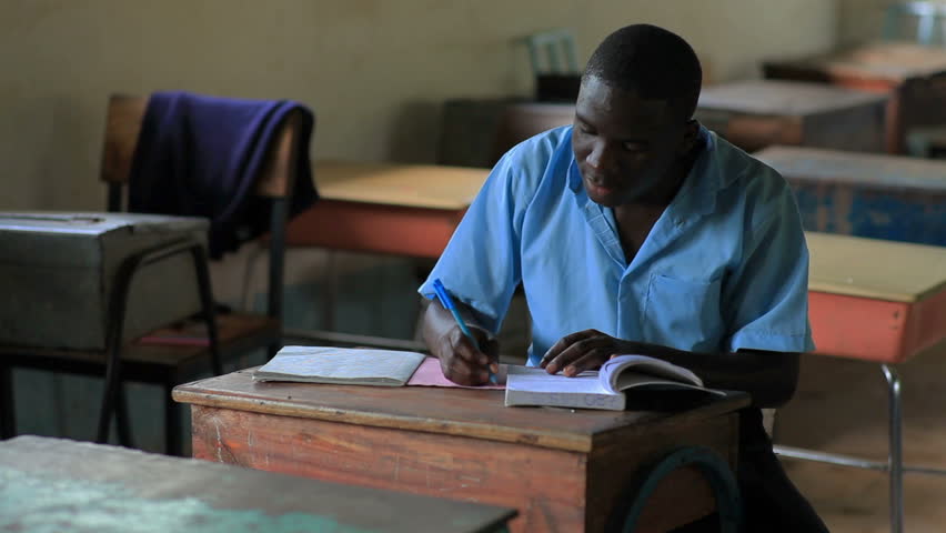 KENYA, AFRICA - CIRCA 2011: School boy doing homework in an empty classroom in